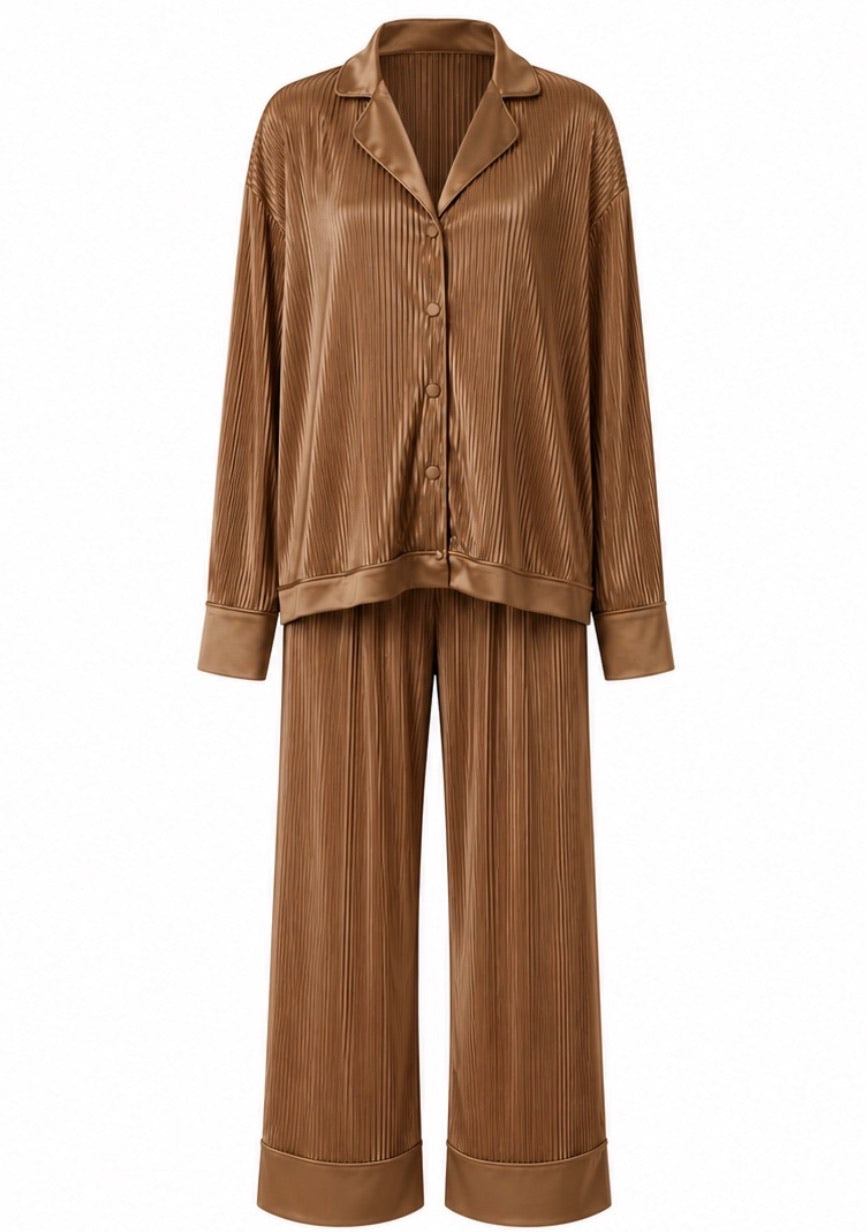 A two-piece pajama set in a warm brown color with a vertical pleated texture, featuring a long-sleeve button-up shirt and matching wide-leg pants, shown against a plain white background.