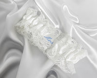 White lace garter on a white  fabric with the personalised word Mrs in blue