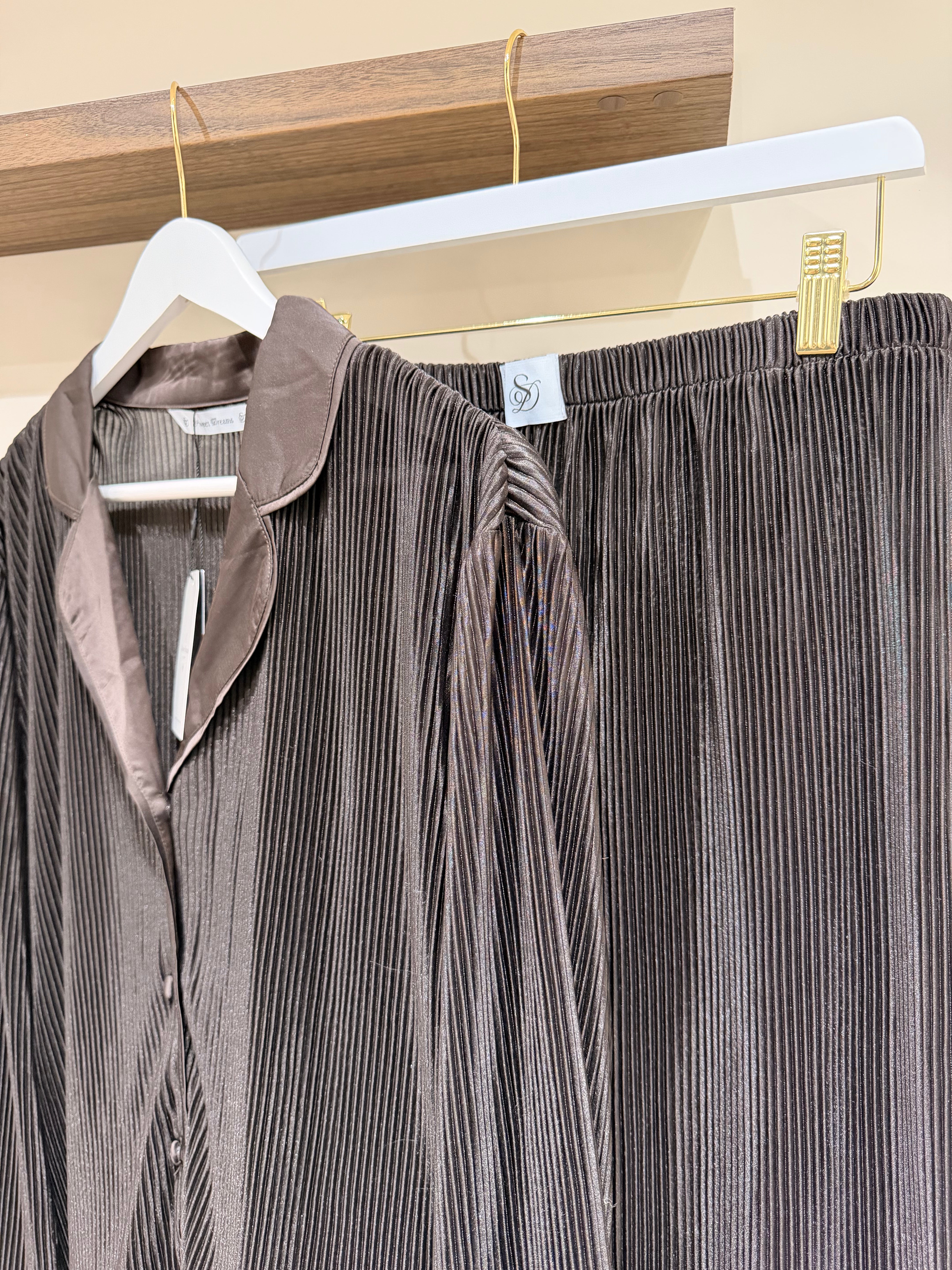 Brown plisse pjs hanging on a rack with a visible tag.
