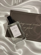 Perfume bottle labeled 'Sleep' on a satin surface with a decorative box.